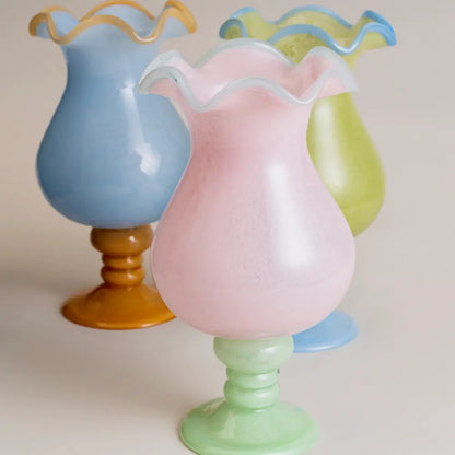 Vase with design original en verre bleu clair, bord ondulé délicat, conçu pour une décoration intérieure raffinée et contemporaine.