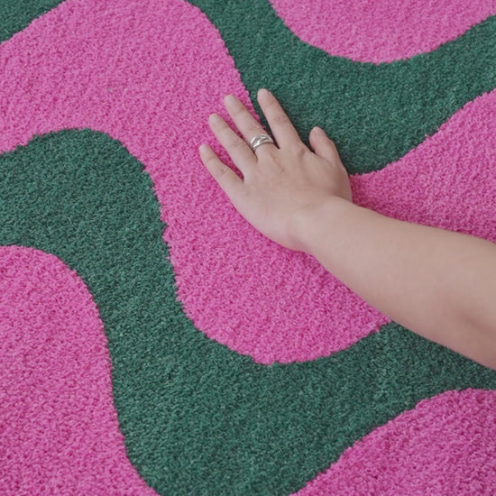 Salon moderne décoré avec un tapis ondulé rose et vert, idéal pour apporter style, confort et accents graphiques.