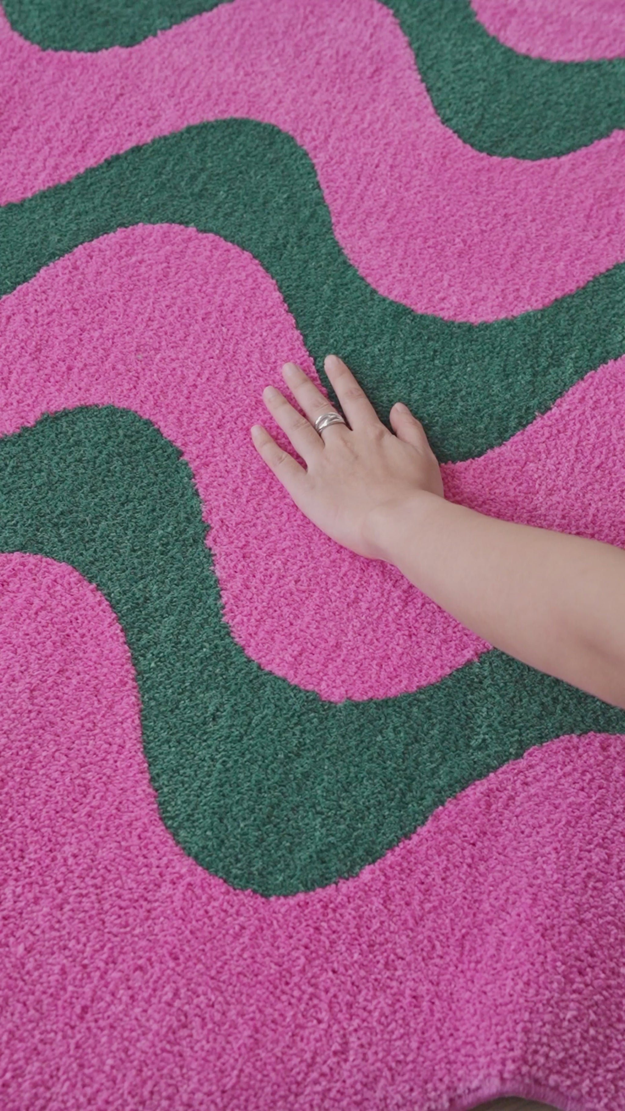 Salon moderne décoré avec un tapis ondulé rose et vert, idéal pour apporter style, confort et accents graphiques.
